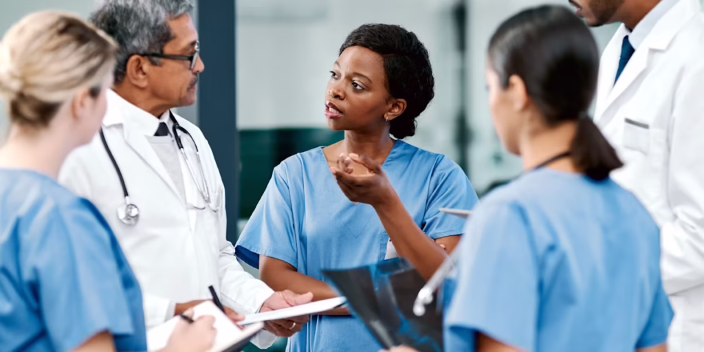 Jennifer John Carbon – Diverse group of medical professionals walking through hospital hallway